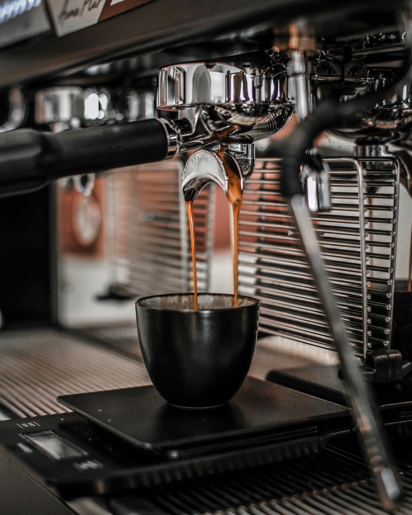 Espresso pouring into a black cup